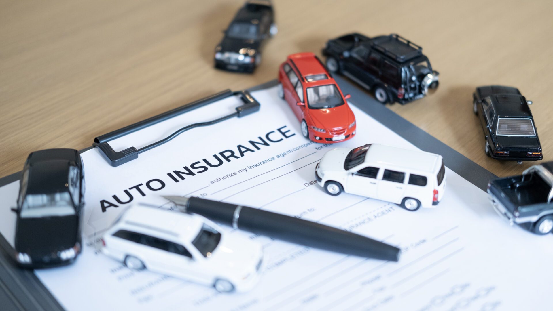 Toy cars on auto insurance document
