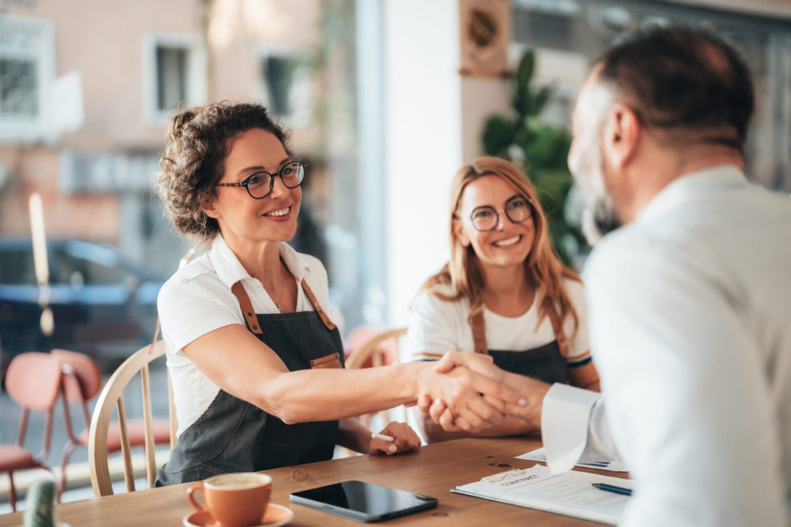 Friendly business handshake in coffee shop